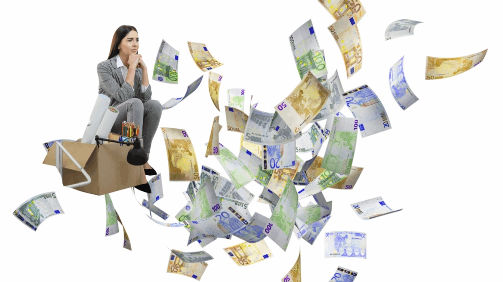 Uitzendkracht zit op verhuisdoos met werkspullen terwijl eurobiljetten door de lucht vliegen – symbool voor gemiste transitievergoeding