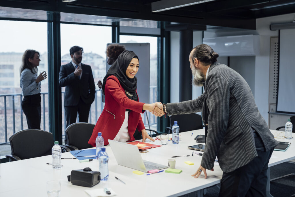 Werkzoekende en werkgever geven elkaar een hand tijdens sollicitatie in Amsterdam