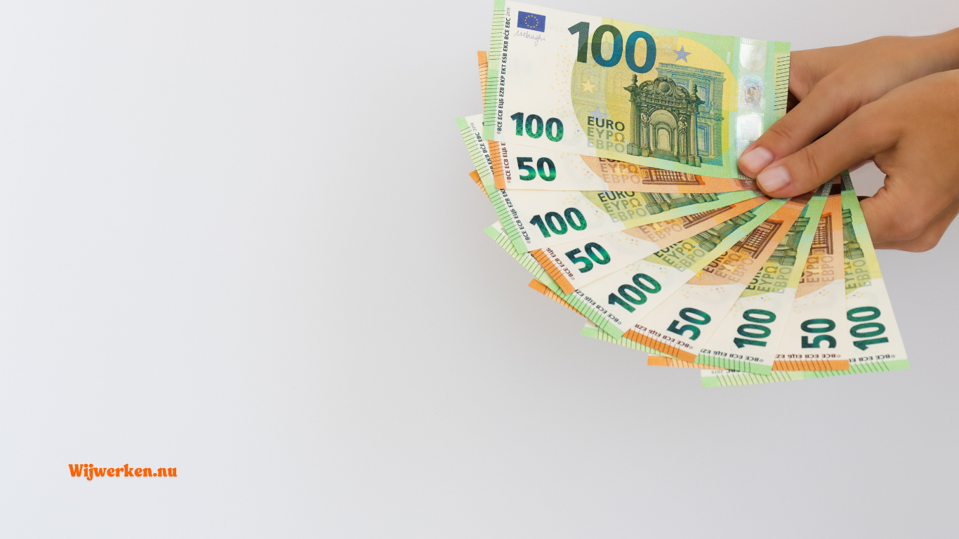 Hand met eurobiljetten als symbool voor transitievergoeding bij uitzendkracht met wisselend salaris