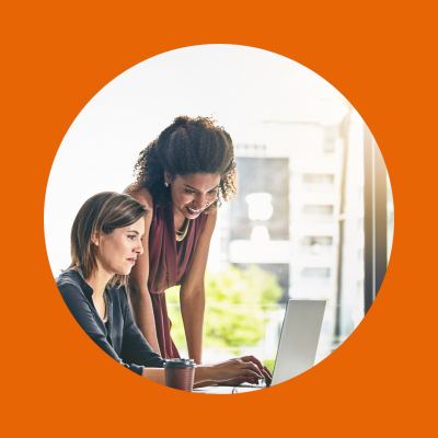 Twee vrouwen werken samen op een laptop, in een professionele omgeving.